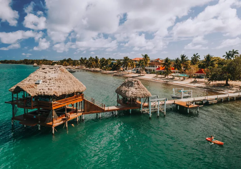 Beach with a long bridge leading to a straw hut