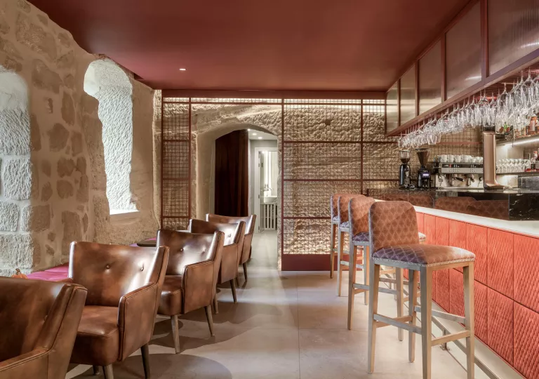 Bar and lounge with leather chairs, and a red bar counter to the right