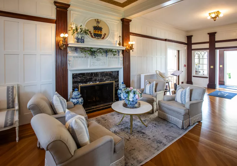 Hotel lobby with cushioned chairs in front of a fireplace
