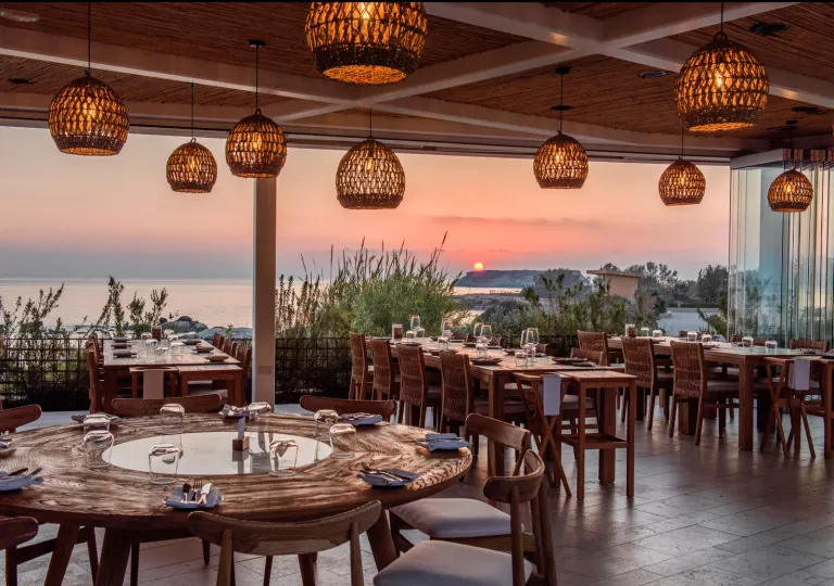 Outdoor patio with dining tables and woven light fixtures