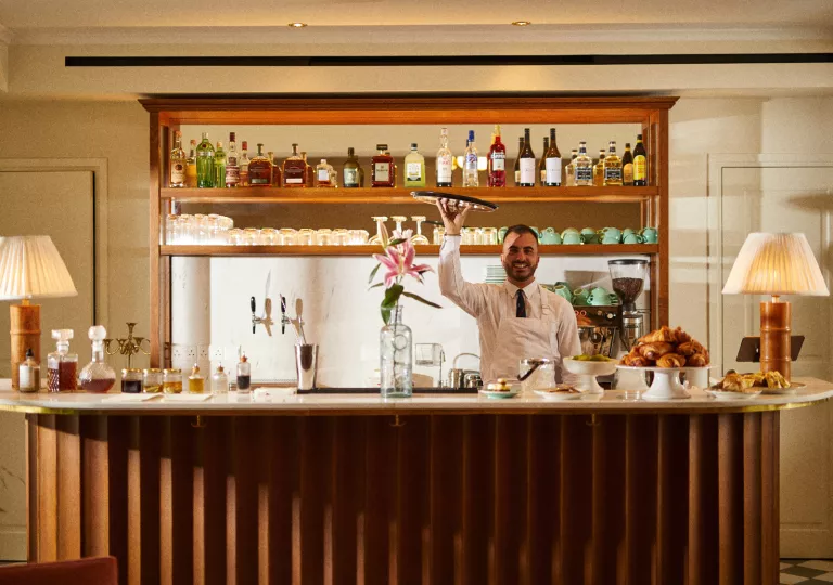 Bar and lounge with a bartender holding up a tray