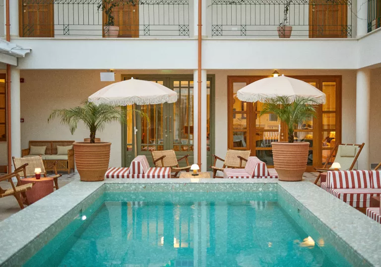 Outdoor pool with red and white striped sofas