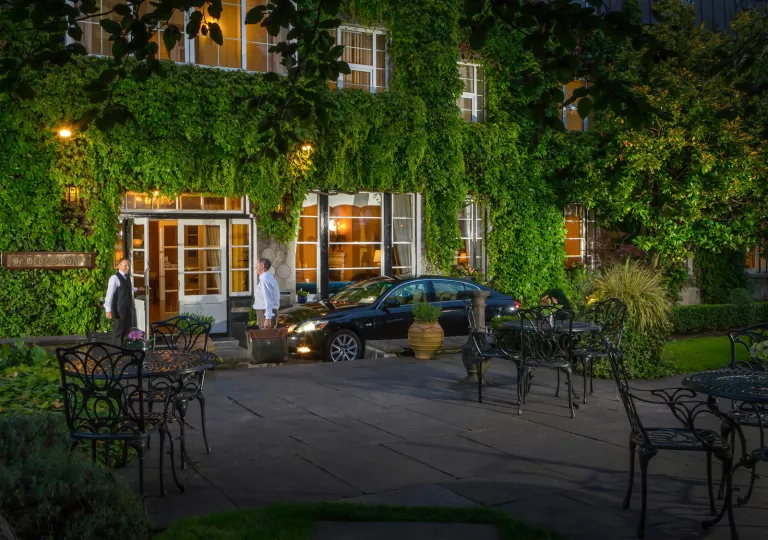 Outdoor car valet in front of a hotel with two men standing in front