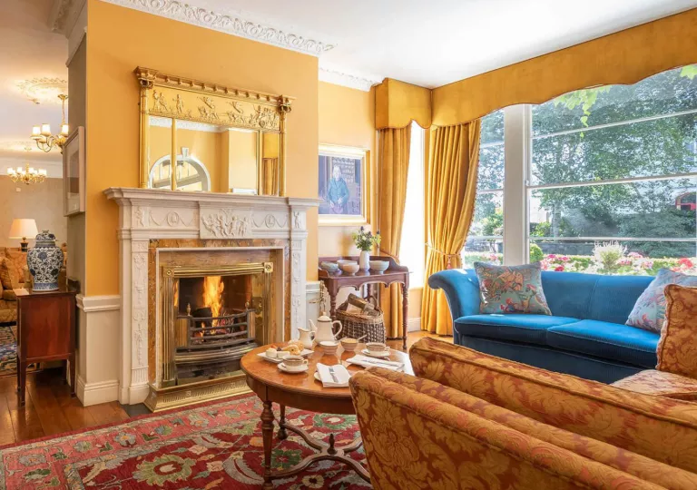 Seating area and lounge with cushioned sofas in front of a fireplace