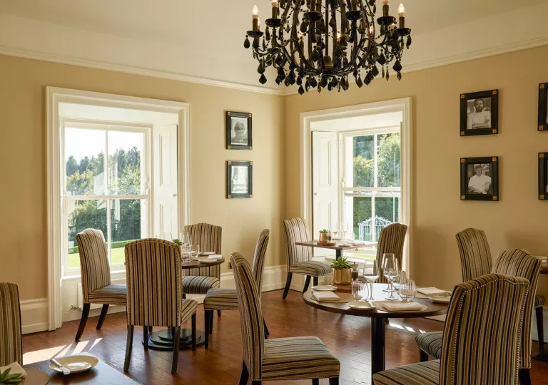 Restaurant dining area with circular tables and striped, beige chairs