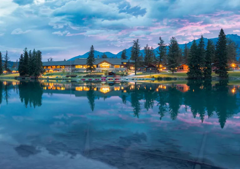 Large lake in front of a large building with pine trees surrounding