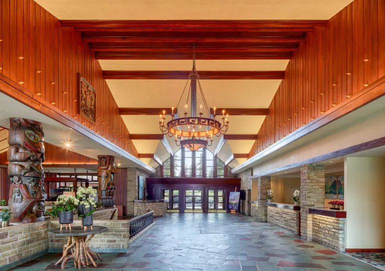 Hotel lobby entrance with stone flooring and large light fixture in the center