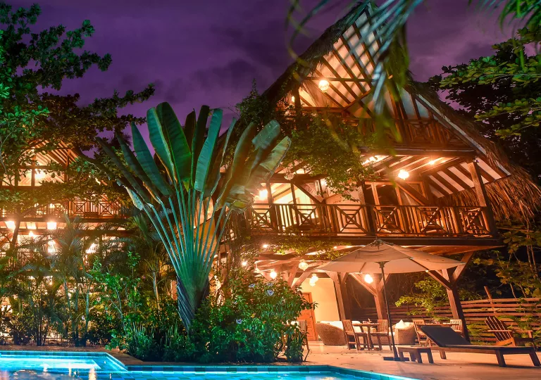 Exterior view of hut-style buildings with wooden balconies in the evening
