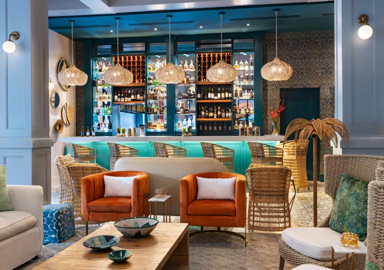 Indoor lounge with a bar in the background and cushioned chairs