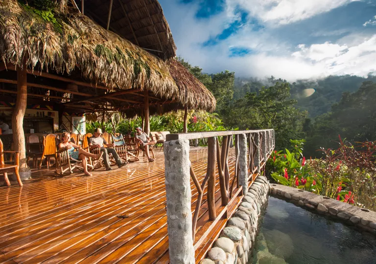 Outdoor patio with wooden and stone fencing, with mountains in the distance