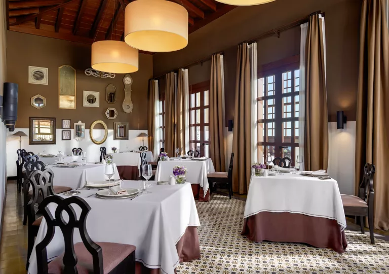 Dining area room with white dining tables and wine glasses on each table