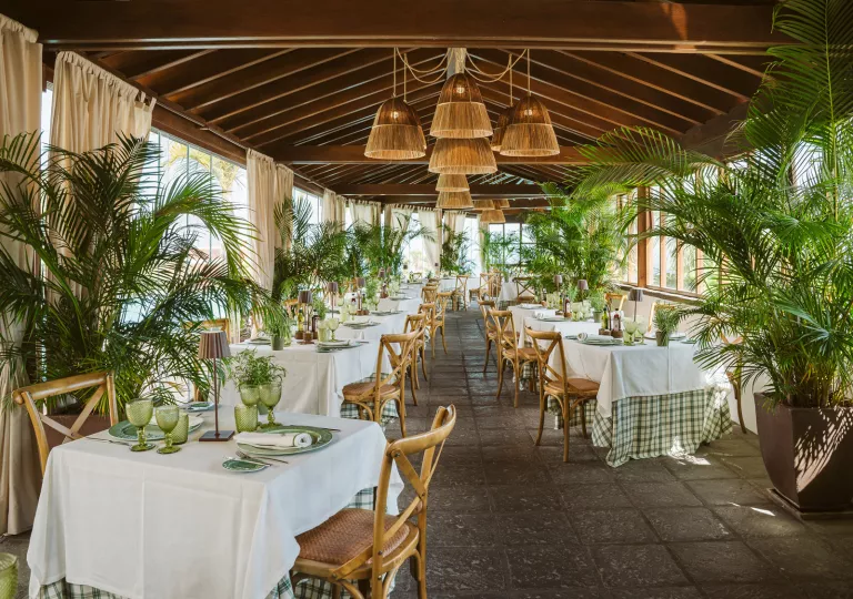 Outdoor patio with outdoor dining tables and chairs, with large windows on either side