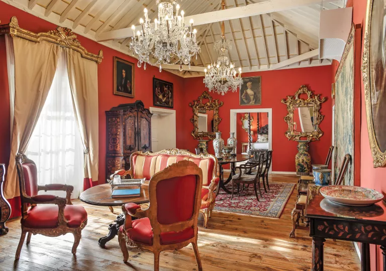 Room with red walls and antique paintings on the walls
