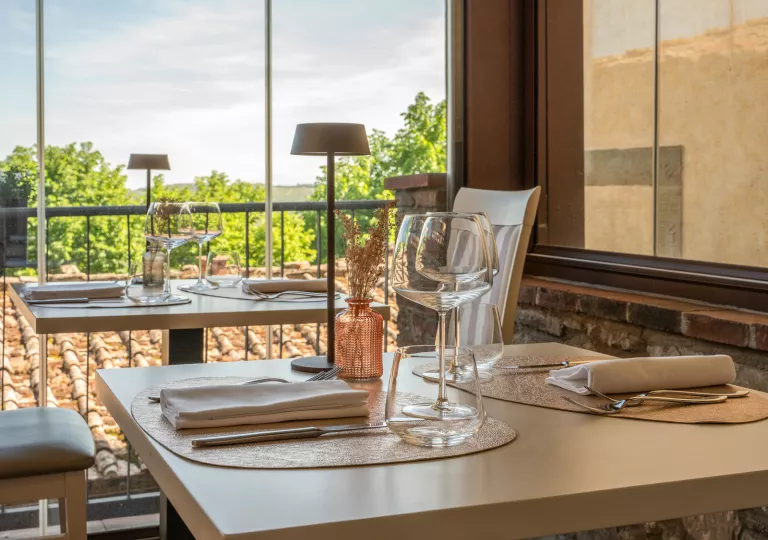Square dining table with wine glasses and silverware
