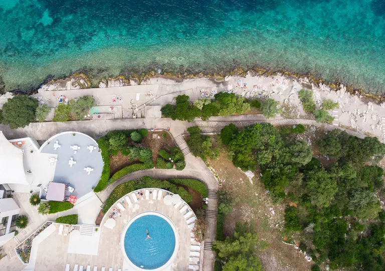 Sky view of an outdoor pool with the ocean in front