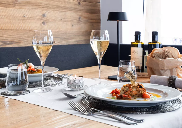 Dining table with two plates of prepared lobster and two wine glasses
