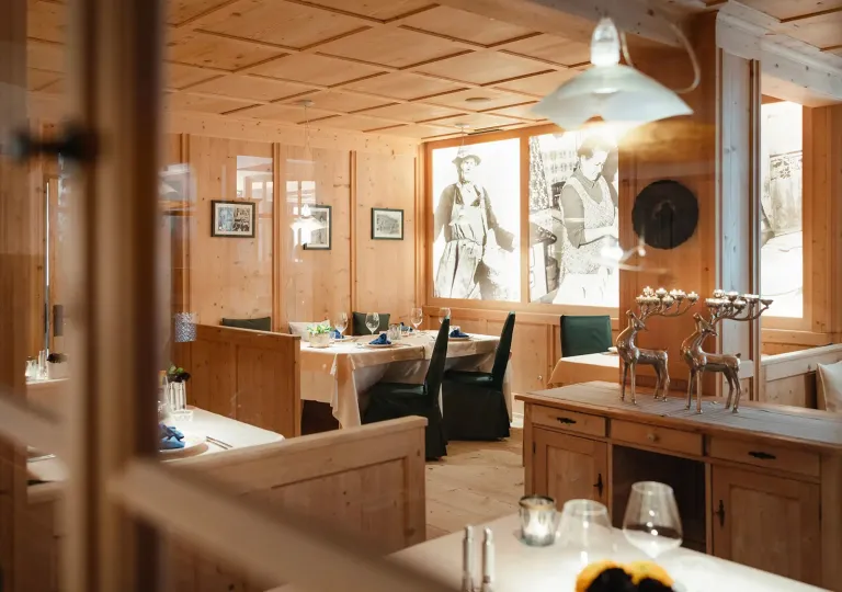 Wooden room with a restaurant, and large portraits on the walls
