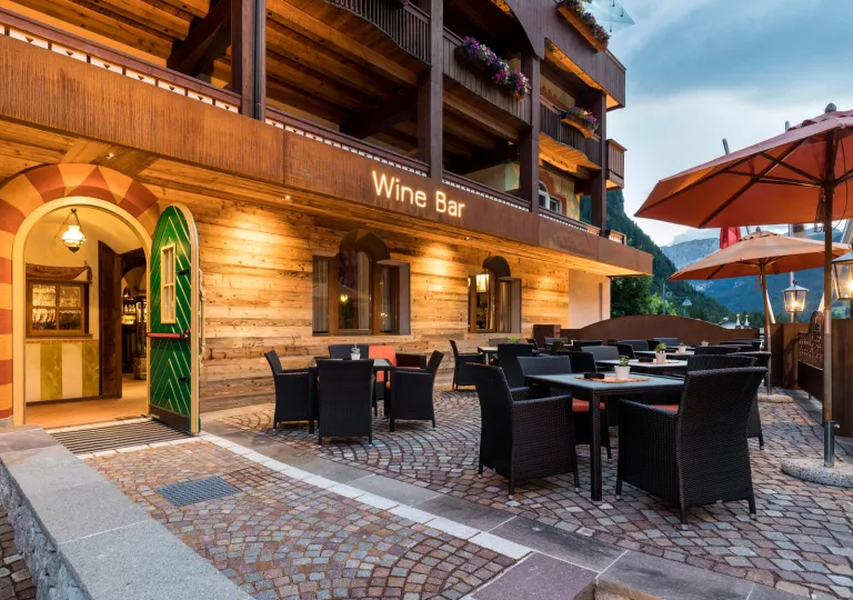 Exterior view of a large wooden hotel building with an illuminated "Wine Bar" sign