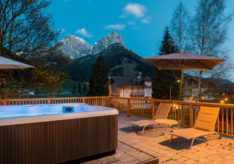 Outdoor patio with a hot tub, with views of mountains in the distance