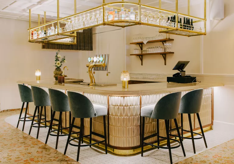 Bar with marble countertops and cushioned gray stools