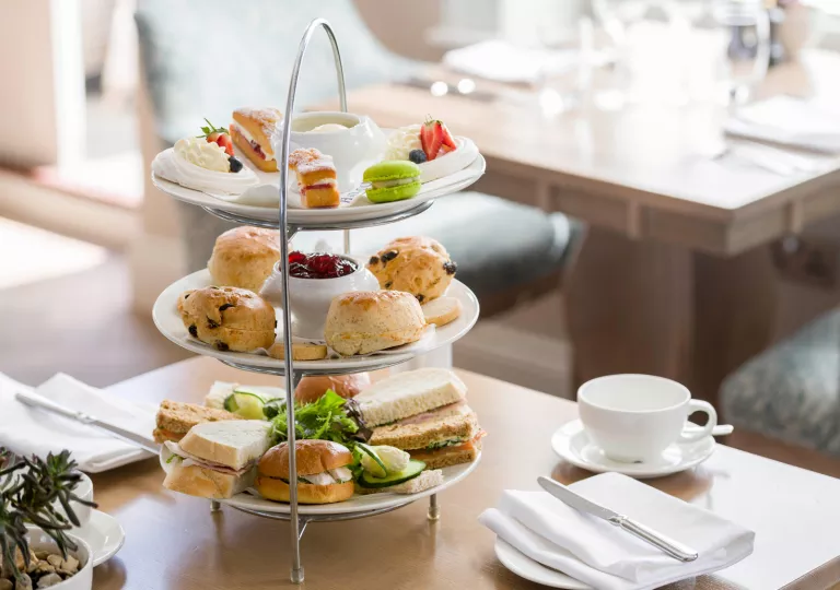 Three-tier plate full of pastries and sandwiches