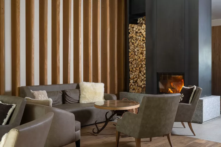 Lounge area with gray, leather couches with a fireplace to the right