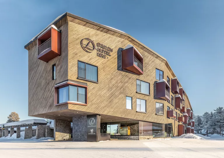 Exterior view of large, elevated hotel building with snow surrounding the building