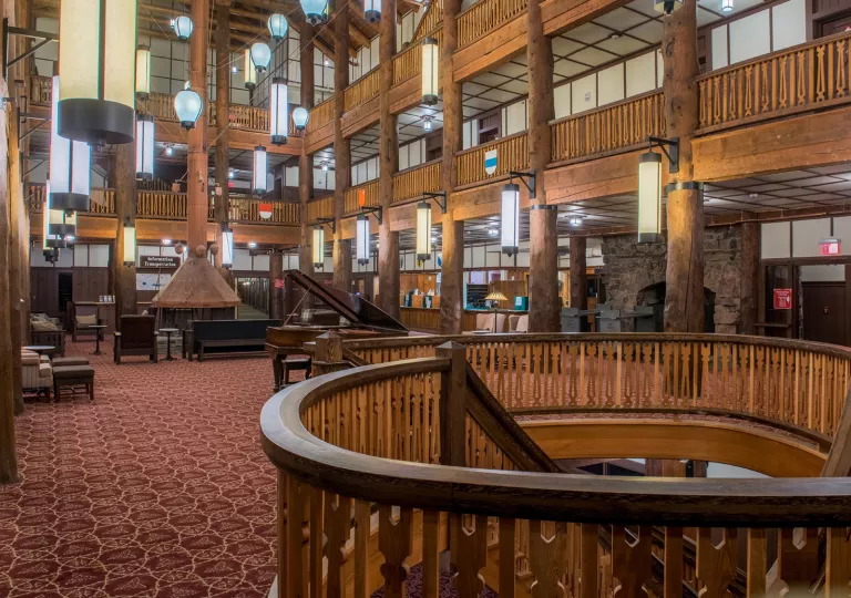 Indoor hotel lobby with large, wood pillars along 3 stories