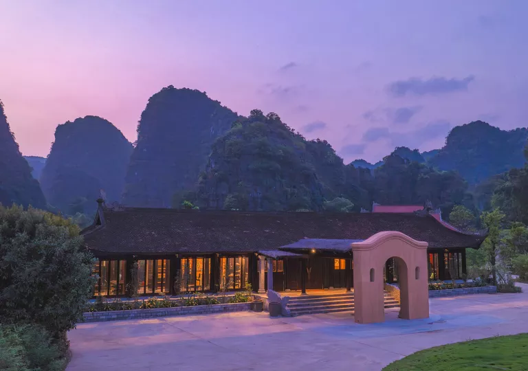 Exterior view of building with sunset and large mountains in the background