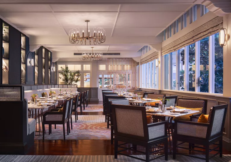 Restaurant dining hall with long wooden tables with wooden chairs