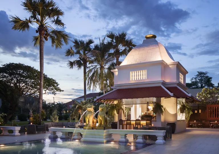 Exterior view of illuminated building with a fountain in front