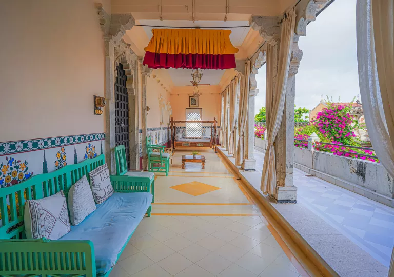 Outdoor balcony with cushioned seats and stone pillars