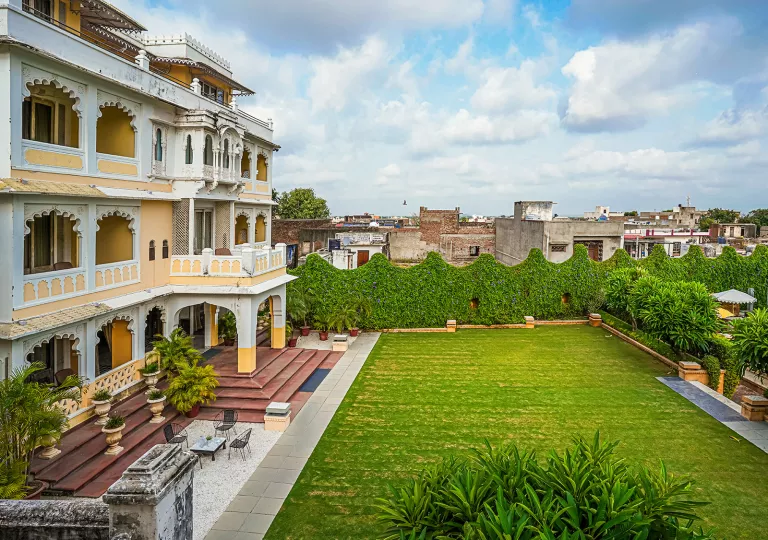 Outdoor grass area with a building with balconies on the left