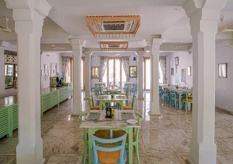 Indoor cafe and restaurant dining area with large white pillars
