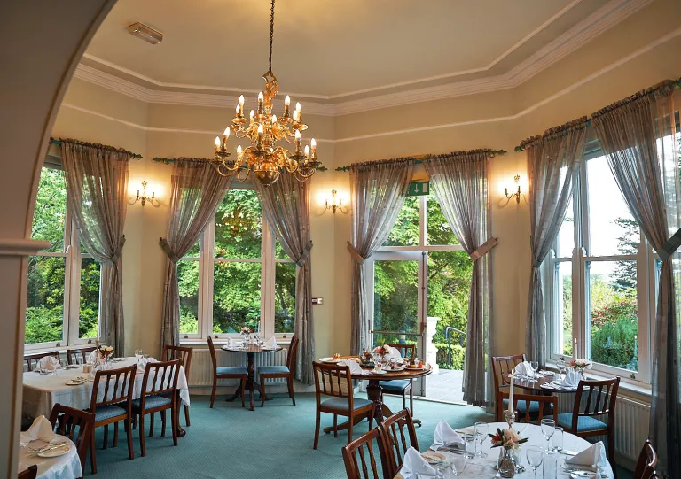 Circular room with circular dining tables and wooden chairs