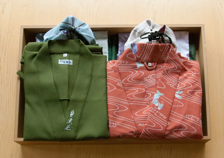 Wooden box filled with a folded green and pink kimono