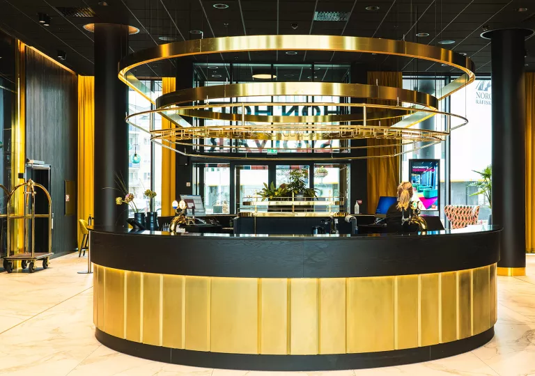 Hotel lobby with a black and gold circular check-in desk