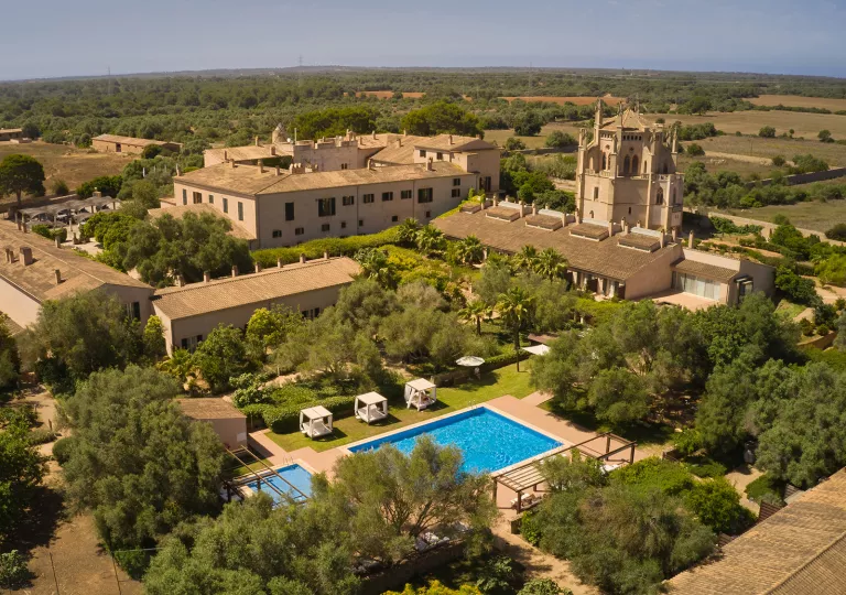 Sky view of brown, hotel buildings with an outdoor pool in the center