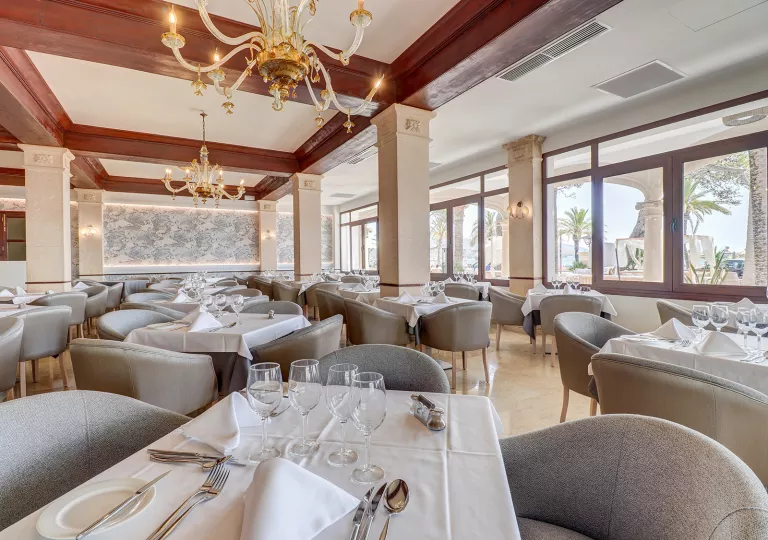Indoor dining hall area with gray chairs and white tables