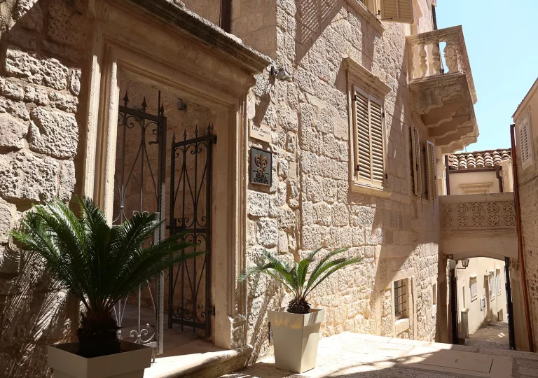 Exterior view of stone building with a narrow staircase to the right