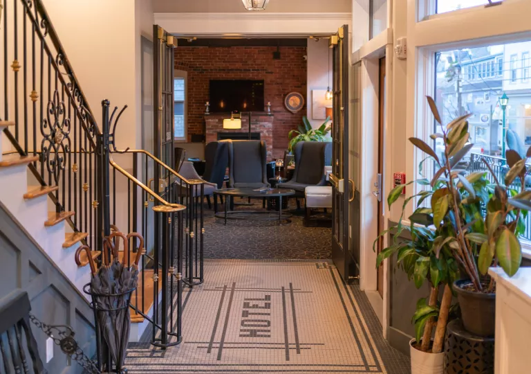 Hotel hallway with a staircase and entry towards another room
