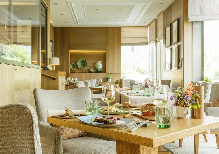 Dining room in a restaurant with plate of food and wine glasses on a table