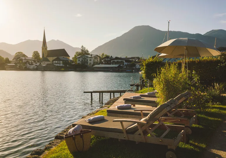 Reclining chairs in a row in front of a large lake
