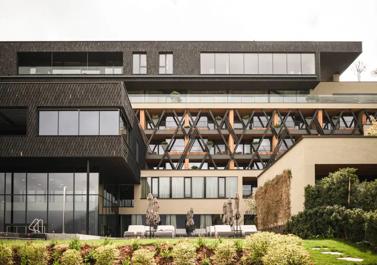 Exterior view of black and beige building complex with large windows and long balconies