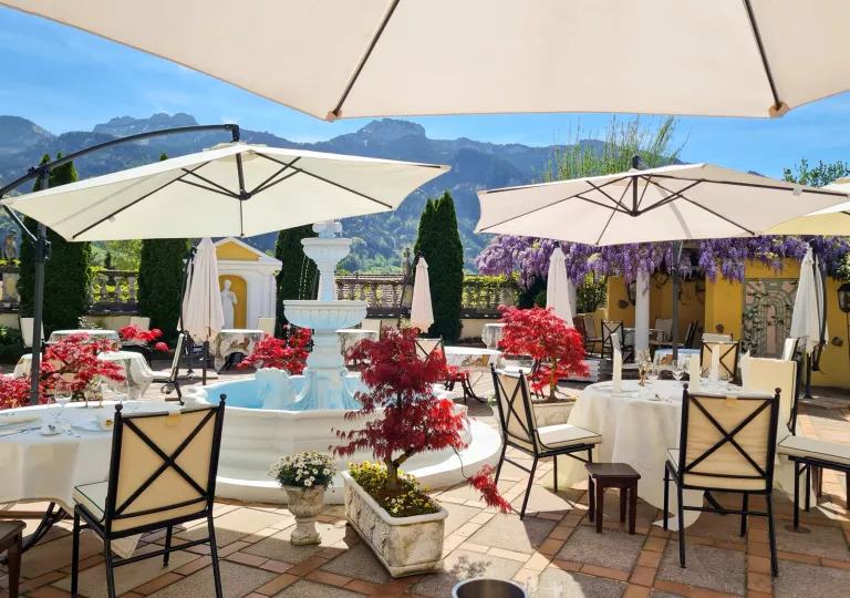 Outdoor patio with dining tables and a stone fountain in the center