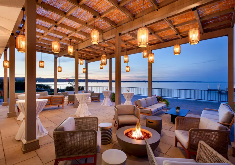 Outdoor patio and balcony with cushioned chairs surrounding fire pits