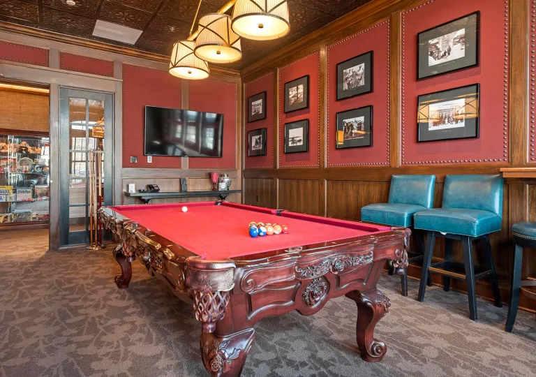 Room with a red pool table and pictures on the walls