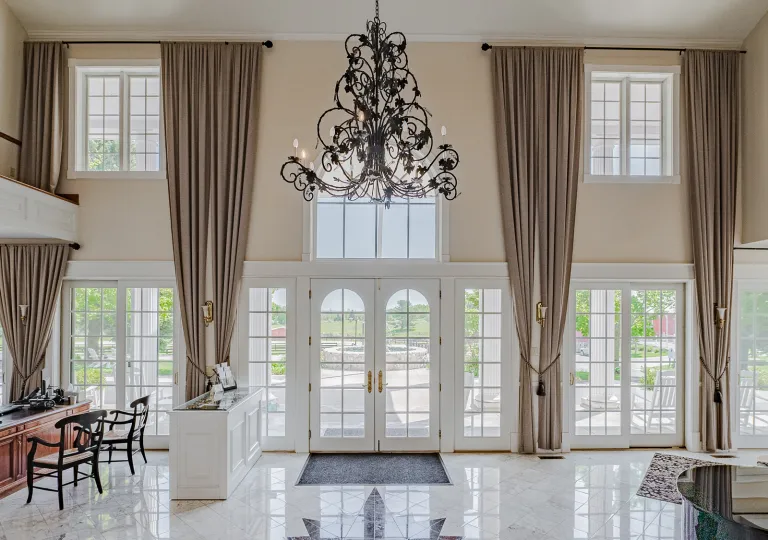 Hotel lobby with marble floors and large walls with windows