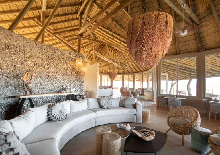 Interior view of a hut with cushioned sofas and coffee tables