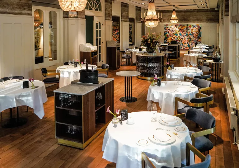 Dining hall with circular tables and cushioned, navy chairs